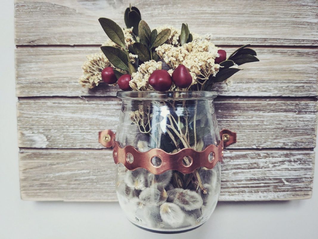 Mini vase with flowers on rustic background