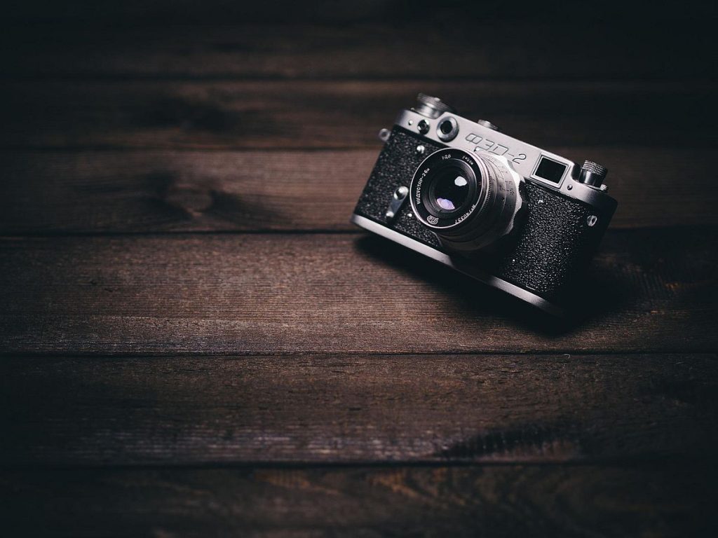 Vintage camera sitting on a dark wood background.