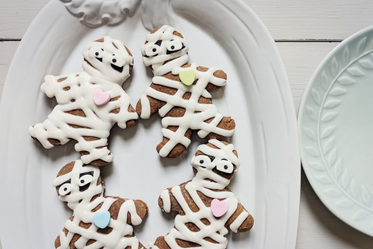 white pumpkin plate with decorated gingerbread mummy cookies