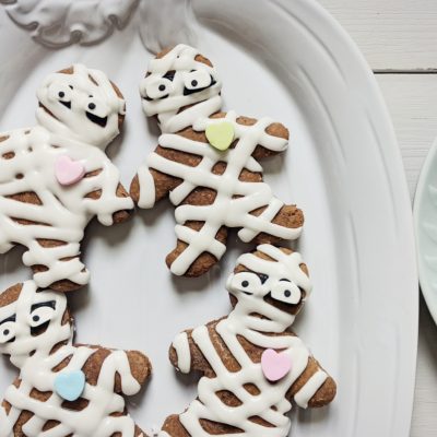 white pumpkin plate with decorated gingerbread mummy cookies