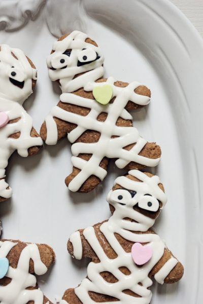 white pumpkin plate with decorated gingerbread mummy cookies