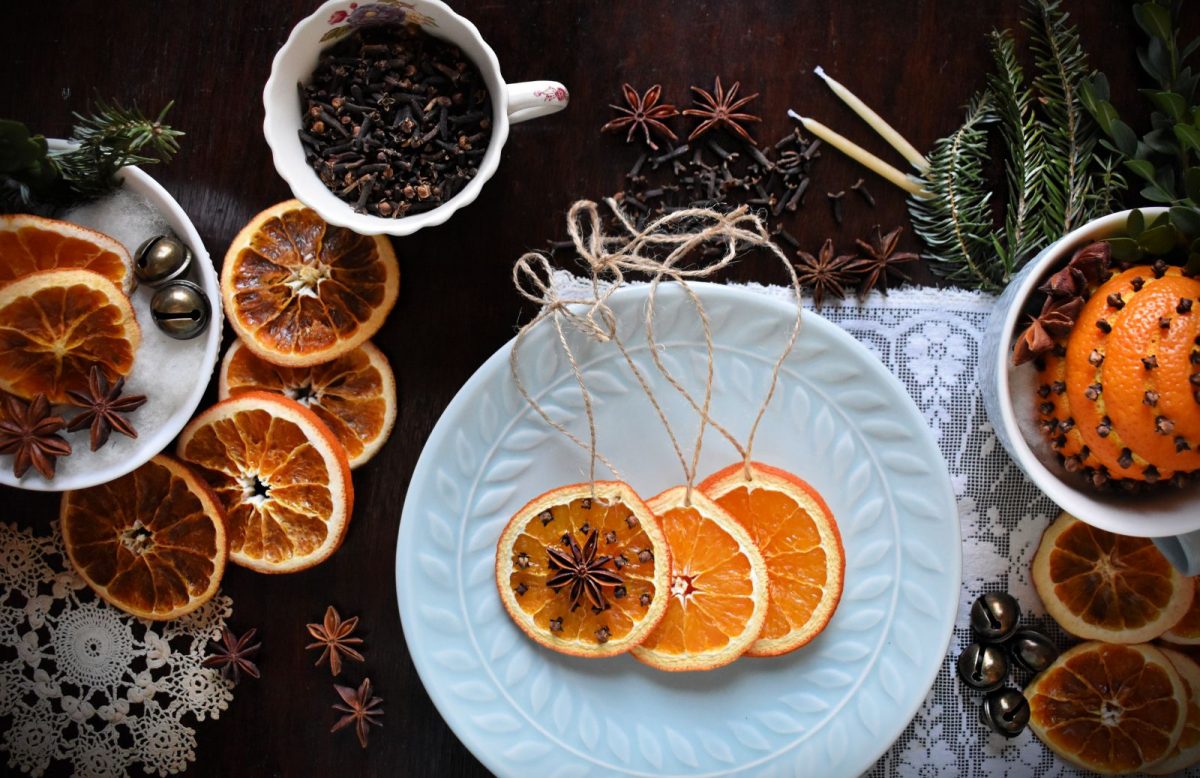Table with dried oranges, cloves, anise, pine and bells.